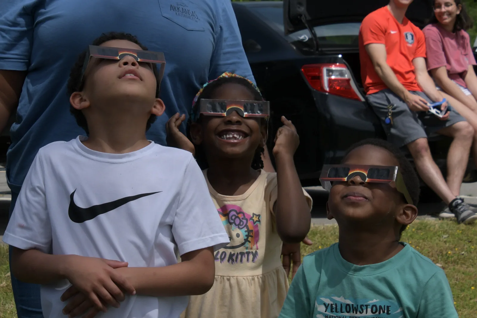 image of three kids with eclipse glasses on