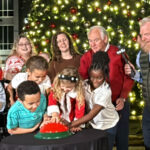 photo of a group of people pushing button to light the tree