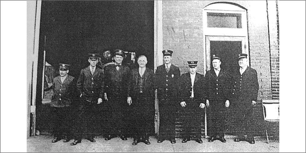 image of historic fire station with firefighters in front