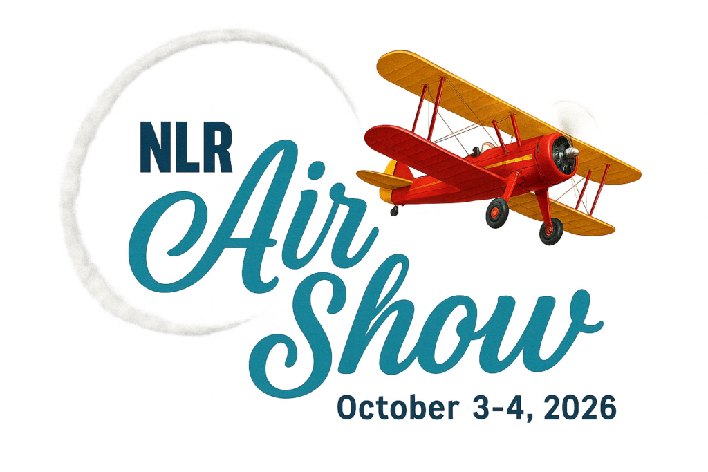 Promotional graphic for the NLR Air Show featuring a red and yellow vintage biplane with a looping white smoke trail and the event dates October 3–4, 2026.